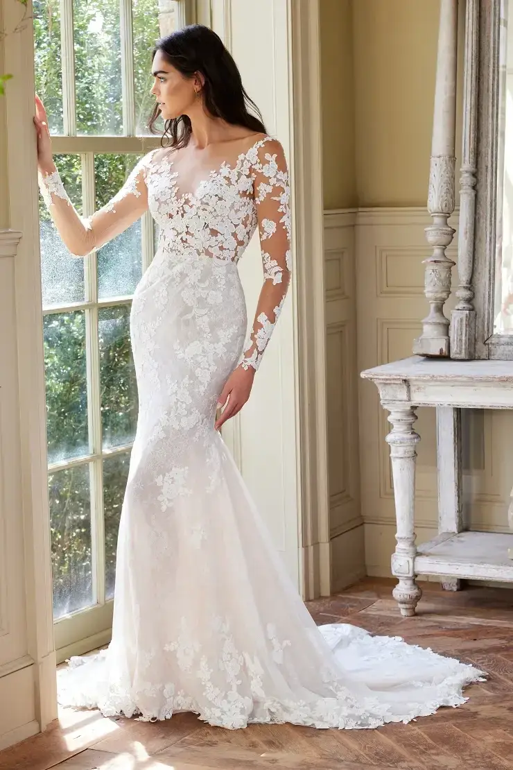 model is wearing an illusion long sleeve lace bridal gown