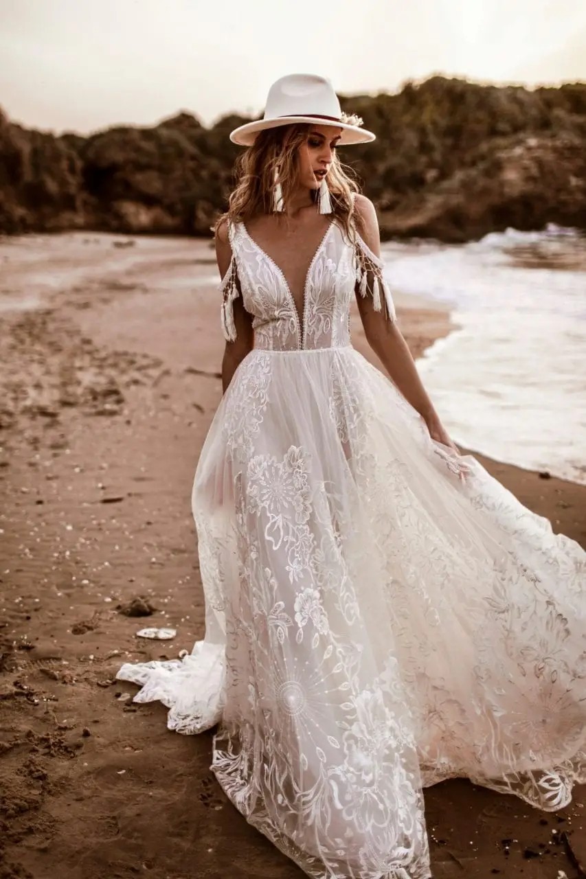 Model is wearing an off the shoulder a-line wedding dress by rish bridal